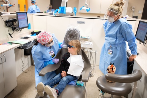 Two dentists providing care for a pediatric dental patient