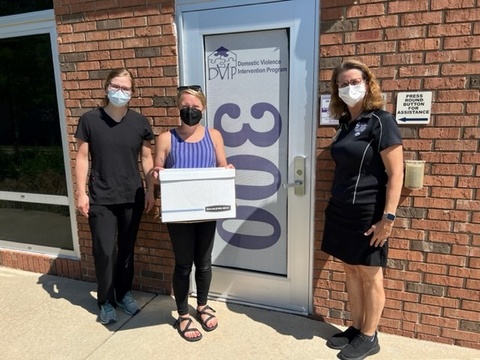 Pediatric dentistry student group co-president Sara Saey and faculty advisor Cathy Skotowski pictured with an administrator from DVIP receiving the boxes of oral hygiene packets.