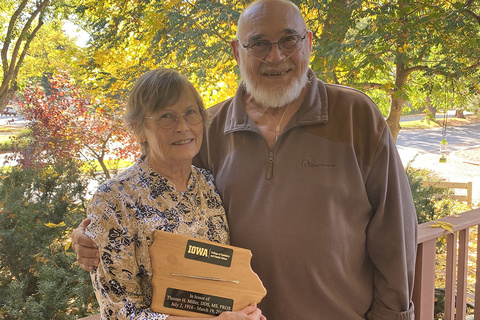 Cathy and Gary Geroy pose for a photo with a plaque honoring Cathy's late father, Dr. Thaxter Miller.