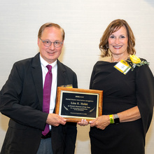 Lisa Holst and Clark Stanford pose for a photo after Holst was presented the 2024 Dental Alumnus of the Year award at the 2024 Alumni Reception.