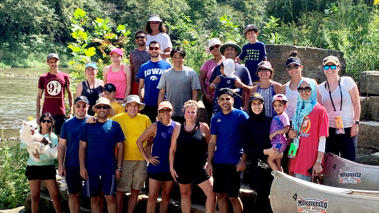 A group of faculty, residents and staff poses after finishing a canoe trip teambuilding exercise.