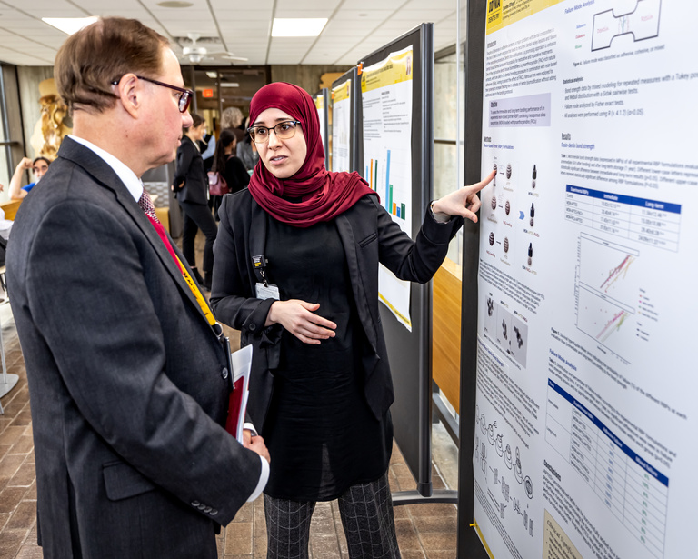 Clark Stanford discussing a poster presentation with the presenter