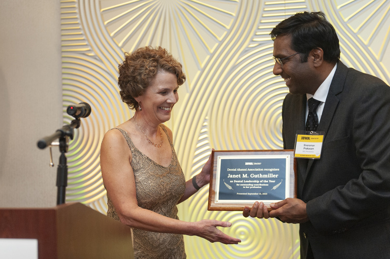 Siva Prakasam presents the Dental Leadership of the Year award to Janet Guthmiller at the 2023 Alumni Reunion at the Radisson Hotel.