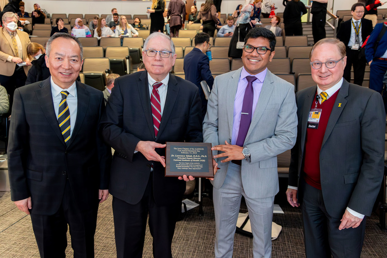 Dr. Lawrence Tabak receives a plaque to memorialize his visit during the 2024 Research Day
