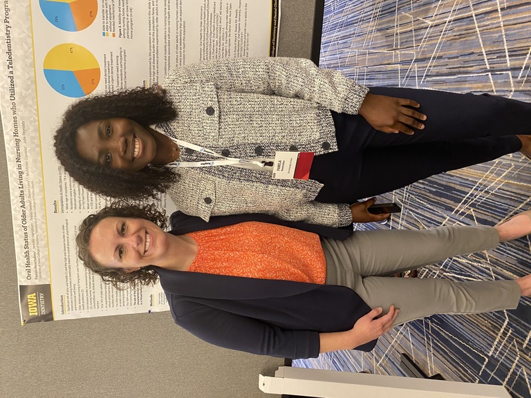 A graduate student with a faculty member at her poster presentation at the 2024 National Oral Health Conference