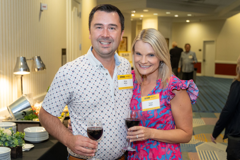 A couple poses for a picture at the 2024 Alumni Reception at The Graduate Hotel.