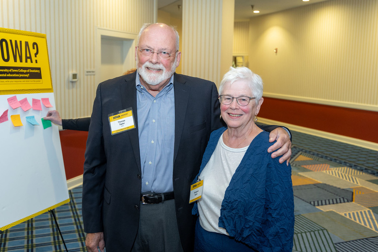 A couple poses for a picture at the 2024 Alumni Reception at The Graduate Hotel.