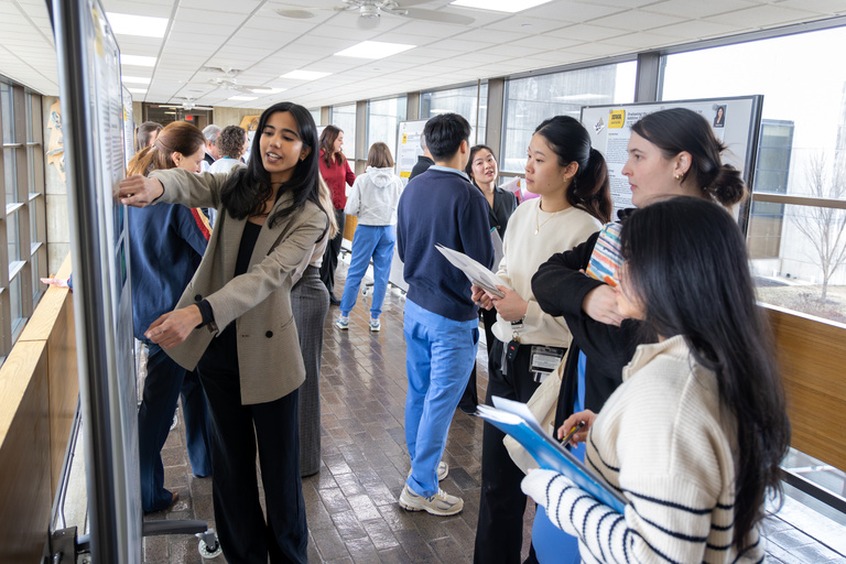 A dental student points out two sections of her poster during a presentation on Feb. 11, 2025.