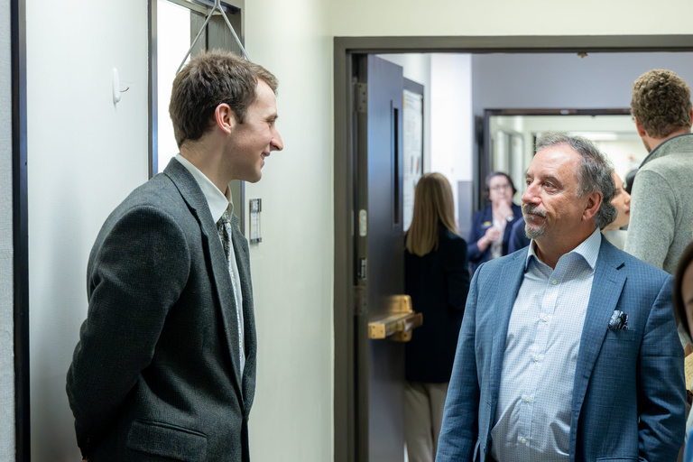 A student researcher shares their work during poster presentations on the 4th floor.