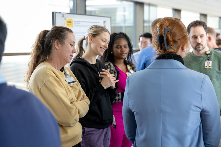 A student researcher shares their work during poster presentations on the 4th-floor link.