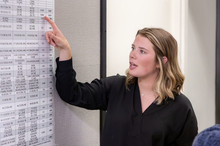 A student researcher shares their work during poster presentations on the 4th floor.