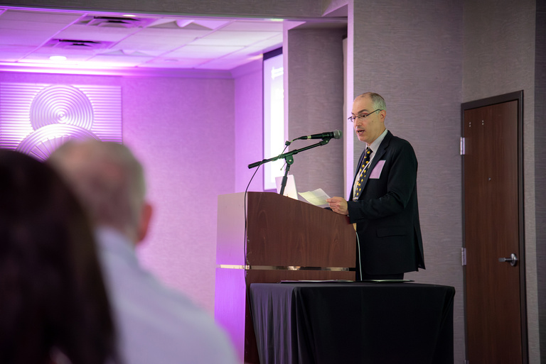 OKU Vice President Dr. Leonardo Marchini speaks at the podium during the 2025 OKU Reception.