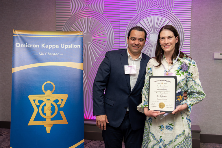 Dr. Cris Vidal takes a picture after being inducted into OKU membership