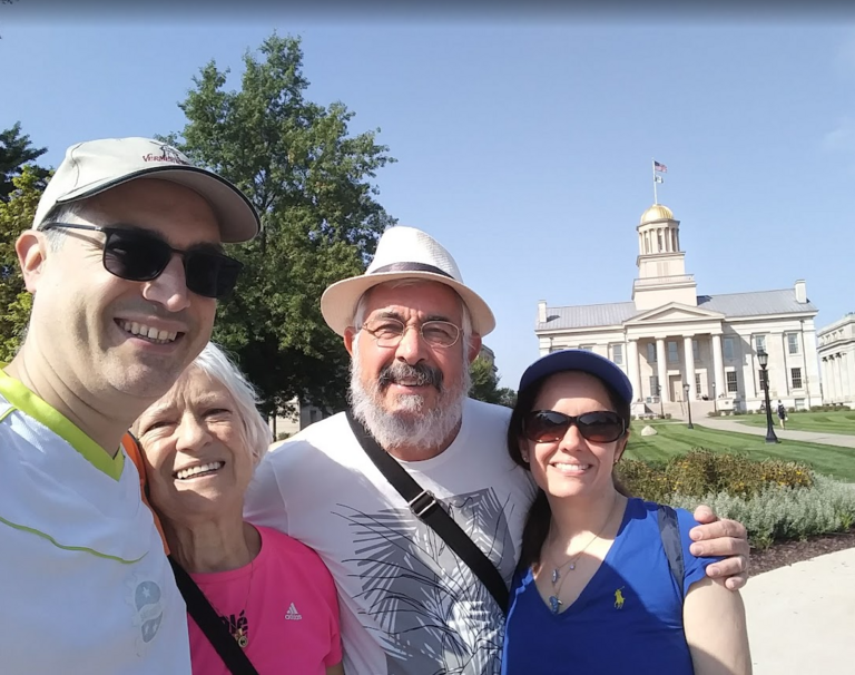 A photo of Leo, his wife Adriana, and parents in front of the Old Capitol in Iowa City.