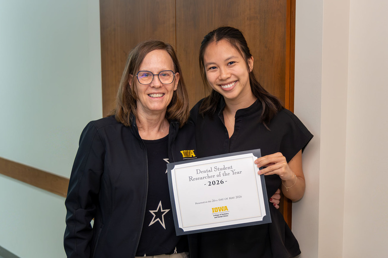 Vi Phan receiving the 2026 Student Researcher of the Year from Dr. Marshall