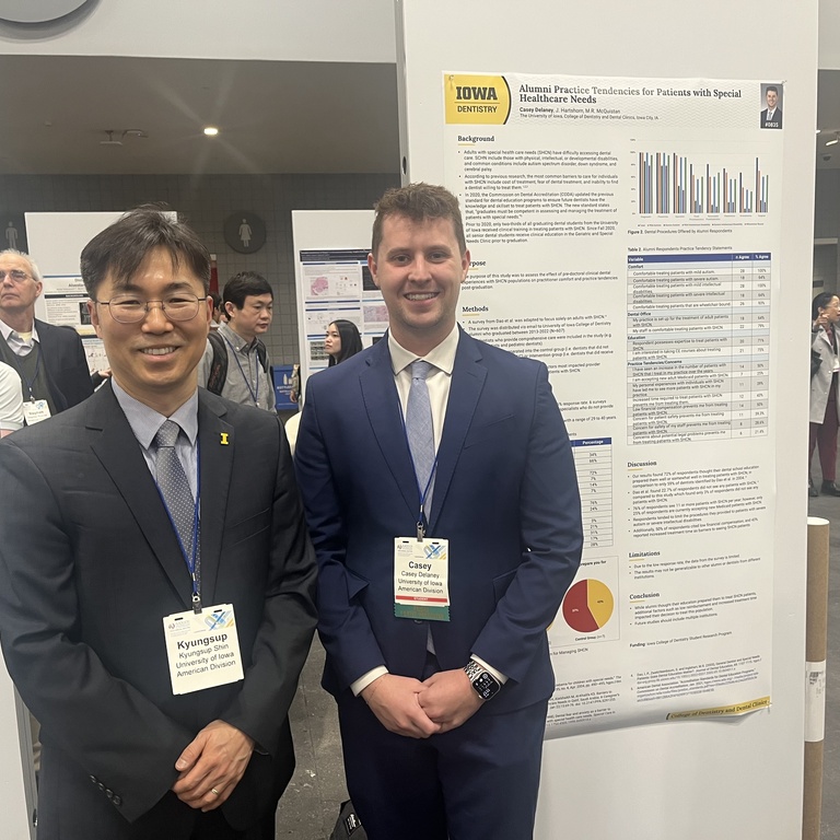 Kyungsup Shin and Casey Delaney pose for a photo in front of Delaney's research poster at the national AADOCR conference.