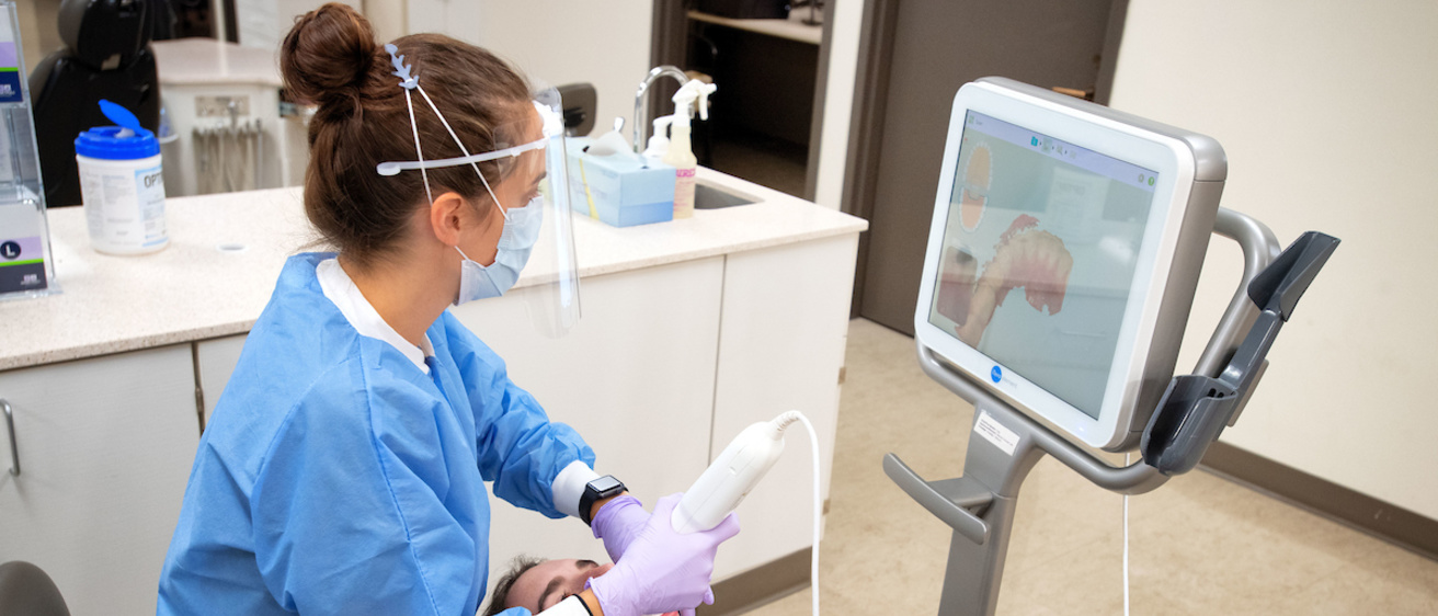A patient being scanned in the orthodontics clinic by a provider