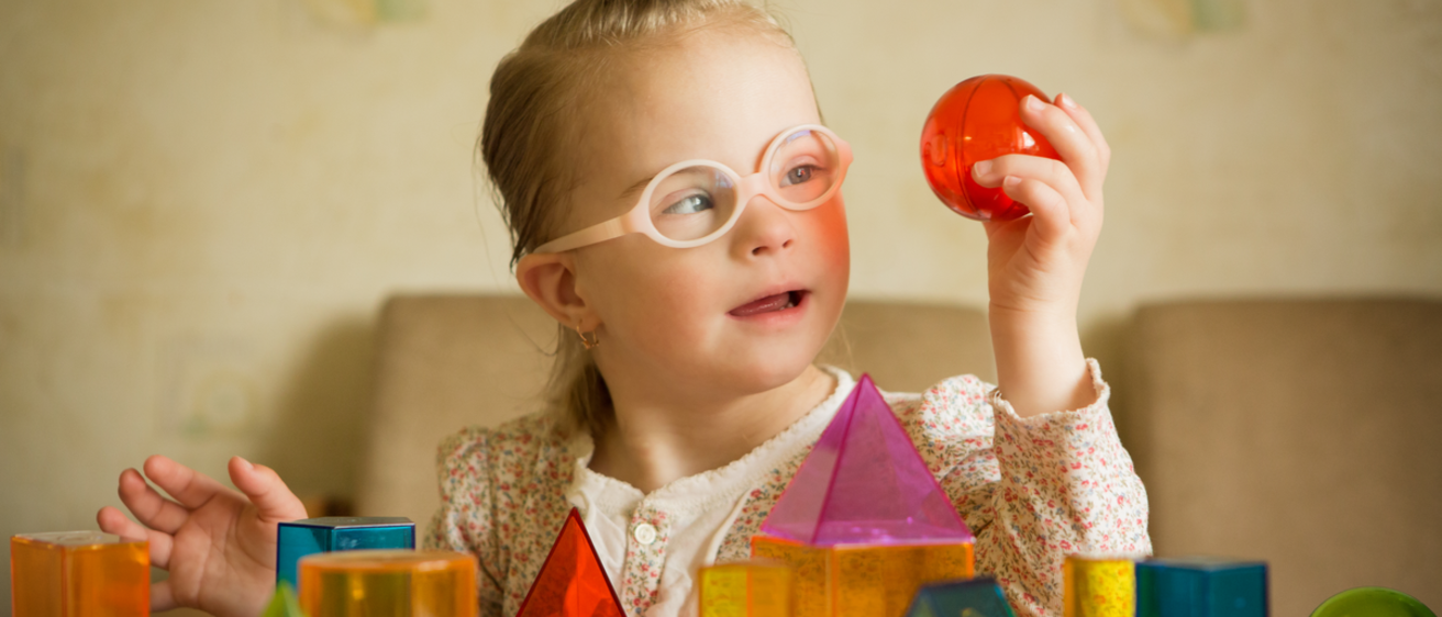 girl with glasses playing with translucent blocks