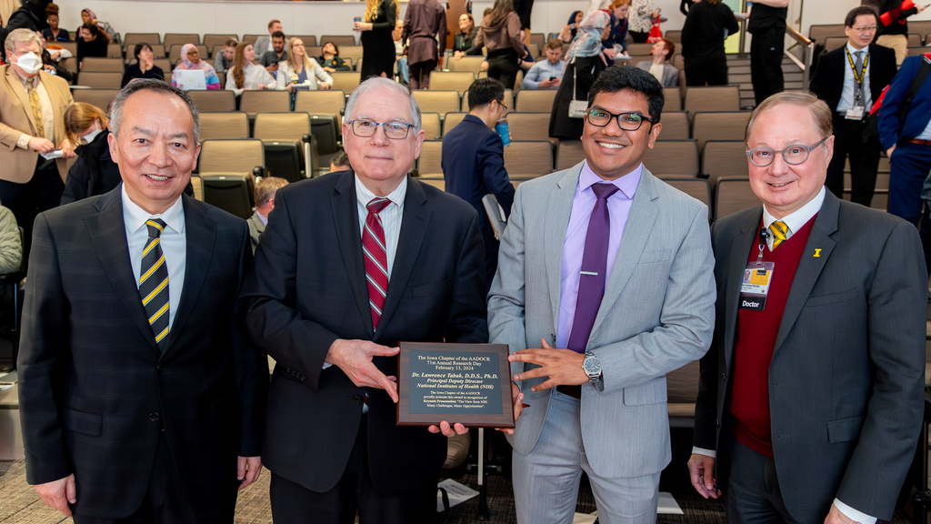 Dr. Lawrence Tabak receives a plaque to memorialize his visit during the 2024 Research Day