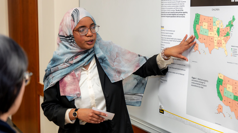 A presenter explains her research during the 2024 AADOCR Research Day